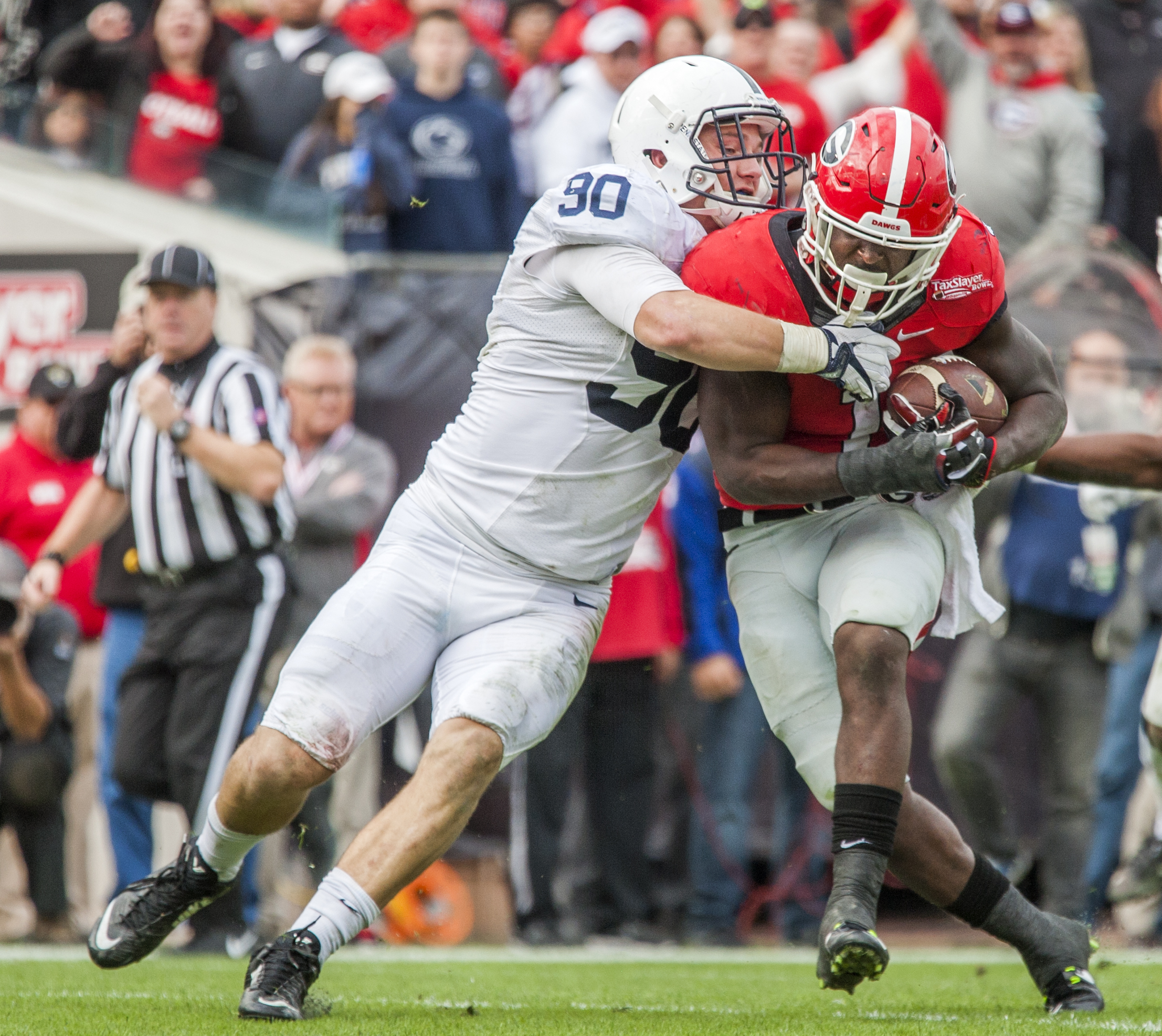 Georgia tailback Sony Michel battles with Penn State Garrett Sickles on a 21-yard touchdown run in the second half of the TaxSlayer Bowl NCAA college football game in Jacksonville, Fla., Saturday, Jan. 2, 2016. Georgia defeated Penn state 24-17. (AP Photo/Mark Wallheiser)