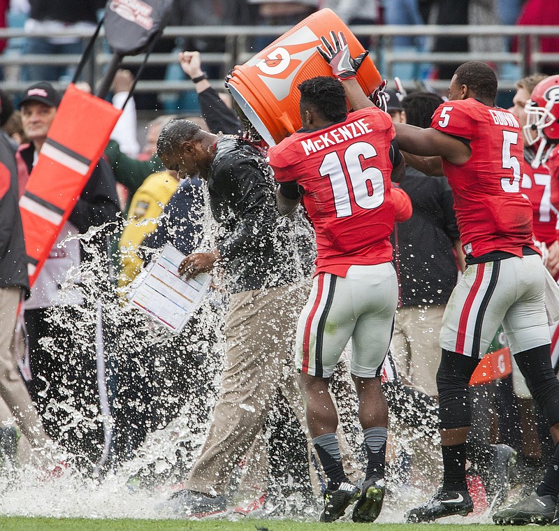 Georgia's Isaiah McKenzie (16) and Terry Godwin (5) dunk interim head coach Bryan McClendon after defeating Penn State 24-17 in the TaxSlayer Bowl NCAA college football game in Jacksonville, Fla., Saturday, Jan. 2,  2016.  (AP Photo/Dave Ferrell)