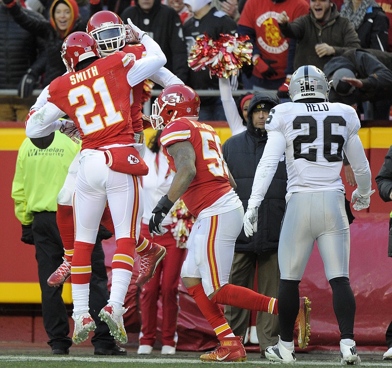 Kansas City Chiefs linebacker Derrick Johnson, right, and cornerback Sean Smith (21) celebrate with safety Ron Parker (38) after an interception by Parker during the first half of an NFL football game against the Oakland Raiders in Kansas City, Mo., Sunday, Jan. 3, 2016.
