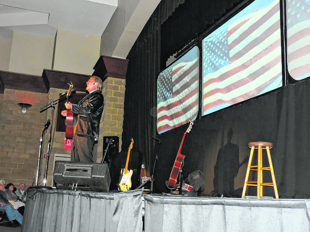 James Rogers plays patriotic tunes on his acoustic guitar onstage at The Colonnade. The first half of Rogers' concert was a patriotic tribute to veterans. The second half, he serenaded the crowd with Christmas songs.