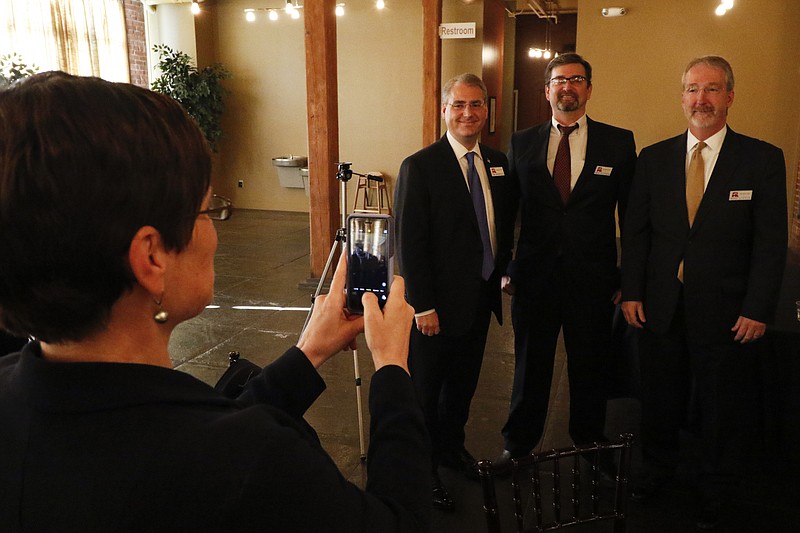 Nancy Patterson takes a photo of Criminal Court Judge Tom Greenholtz, Assistant District Attorney Boyd Patterson and Assistant Public Defender Mike Little before they speak in front of fellow republicans during a Pachyderm Club meeting at The Mill on Monday, January 4, 2015.