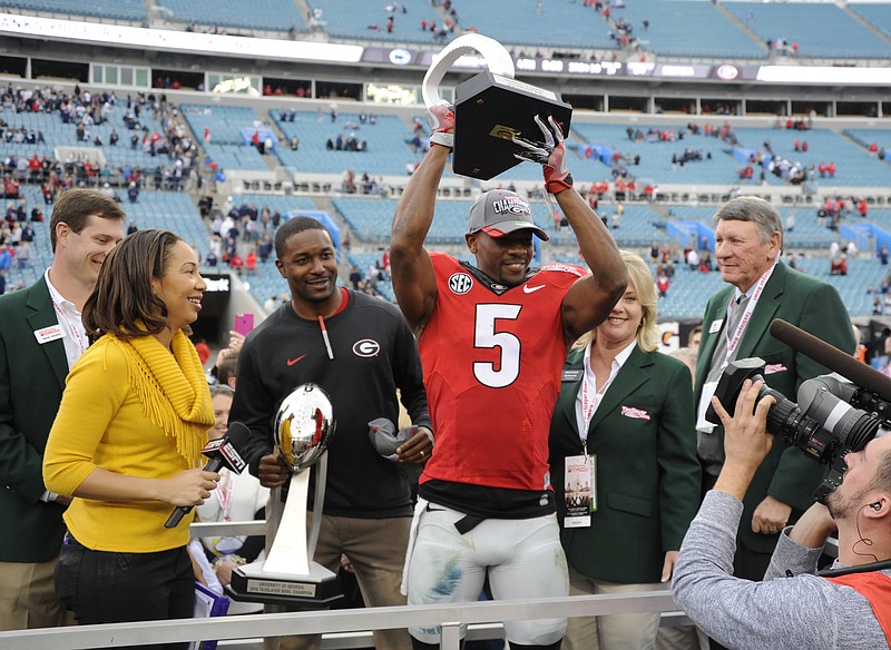 Georgia freshman receiver Terry Godwin holds up the MVP trophy from Saturday's TaxSlayer Bowl.