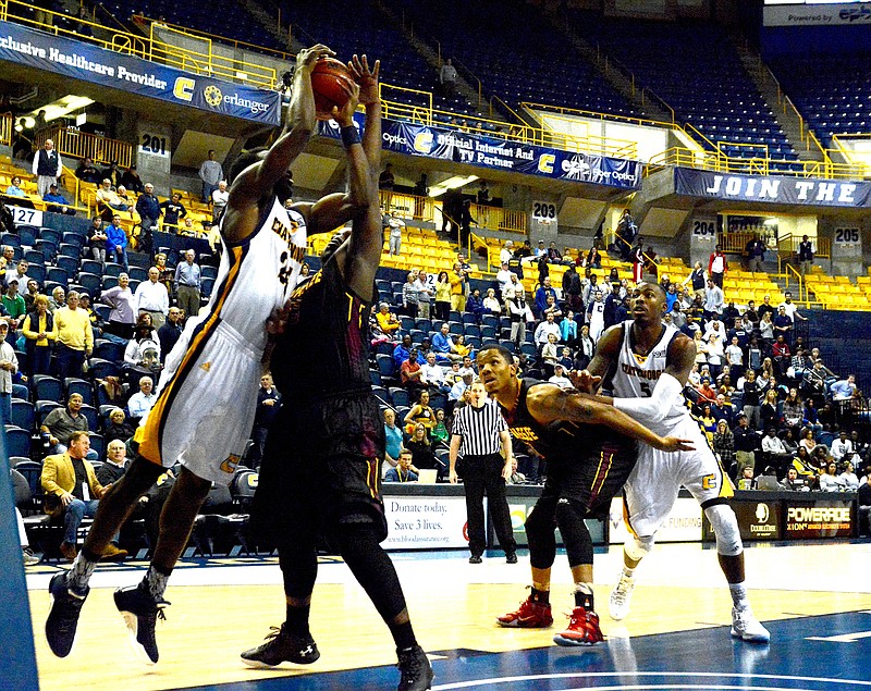 From left, UTC's Casey Jones and Hiwasee's Kaseem Davidson battle for the ball while Hiwasee's Aario Johnson and UTC's Justin Tuoyo battle for position as the University of Tennessee at Chattanooga hosts Hiwassee College in a men's basketball game Monday, Nov. 16, 2015, in Chattanooga, Tenn. UTC won their home opener by a score of 94-55.