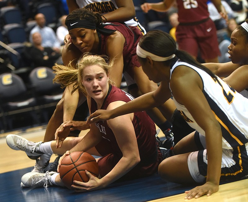 Harvard's Madeline Raster tries to hang on to the ball as teammate Destiny Nunley, back left, and UTC's' Keiana Gilbert reach for the ball Monday, January 4, 2016, at McKenzie Arena in Chattanooga, Tenn.
