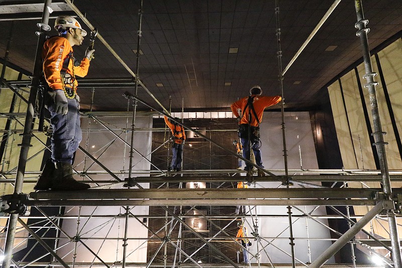 Staff Photo by Dan Henry / The Chattanooga Times Free Press- 1/5/16. Hector Merida, left, and other workers with Anderson Guttering and Tree build a scaffolding to install a new audio speaker system at the Tennessee Aquarium IMAX theater on Tuesday, January 5, 2016. The Tennessee Aquarium IMAX is being converted from a standard 70mm projection theater into a cutting edge IMAX laser projection system theater complete with a 12-point audio system and 3D sound sphere. The renovations are expected to take nearly a month and cost $1.2 million dollars. 