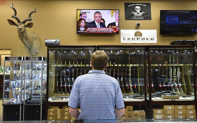 Brett Busbee, sales associate at Southeastern Armory, a gun store in Augusta, Ga., watches as President Barack Obama speaks at the White House about his gun control measures Tuesday.