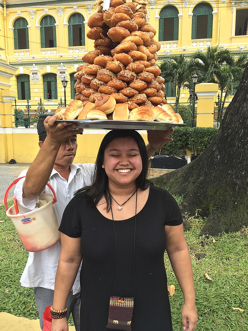 Rachael Weaver interacts with a food vendor outside a Saigon post office.