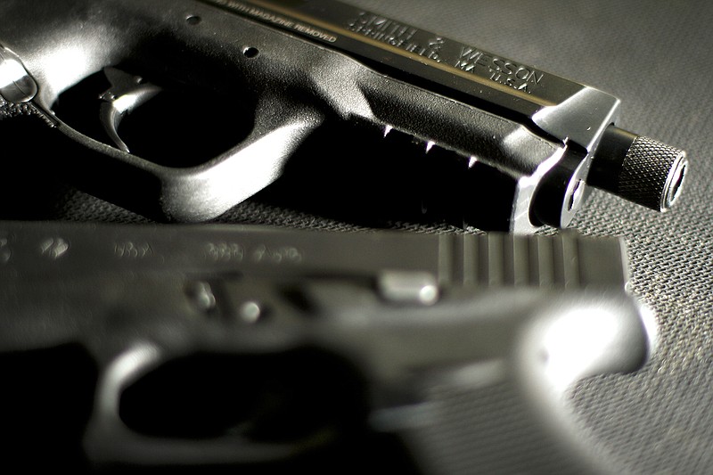 Staff Photo by Dan Henry / A Smith and Wesson M&P 9 and Glock42 380 semi-automatic handgun rest on a plastic mat inside of Shooters Depot.