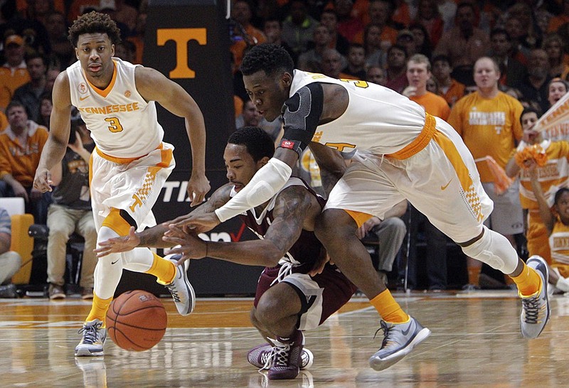 Tennessee guard Devon Baulkman, right, battles for the ball with Texas A&M guard Anthony Collins (11) during the first half of an NCAA college basketball game Saturday, Jan. 9, 2016, in Knoxville, Tenn. Tennessee guard Robert Hubbs III (3) trails. (AP Photo/Wade Payne)