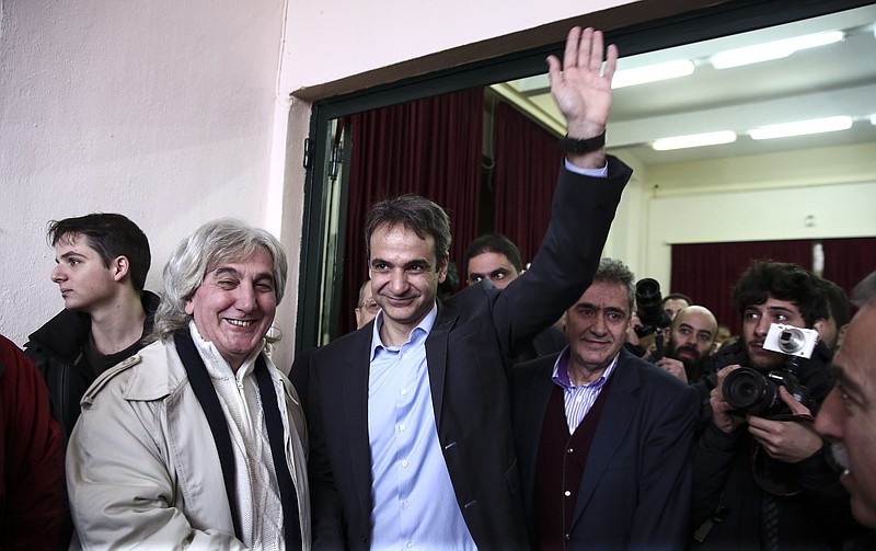 
              Candidate Kyriakos Mitsotakis, center, waves to supporters as he leaves a polling station at Kifissia suburb, north of Athens, on Sunday, Jan. 10, 2016. Greece's conservative New Democracy party conducts a nationwide voting to elect a new leader. (AP Photo/Yorgos Karahalis)
            