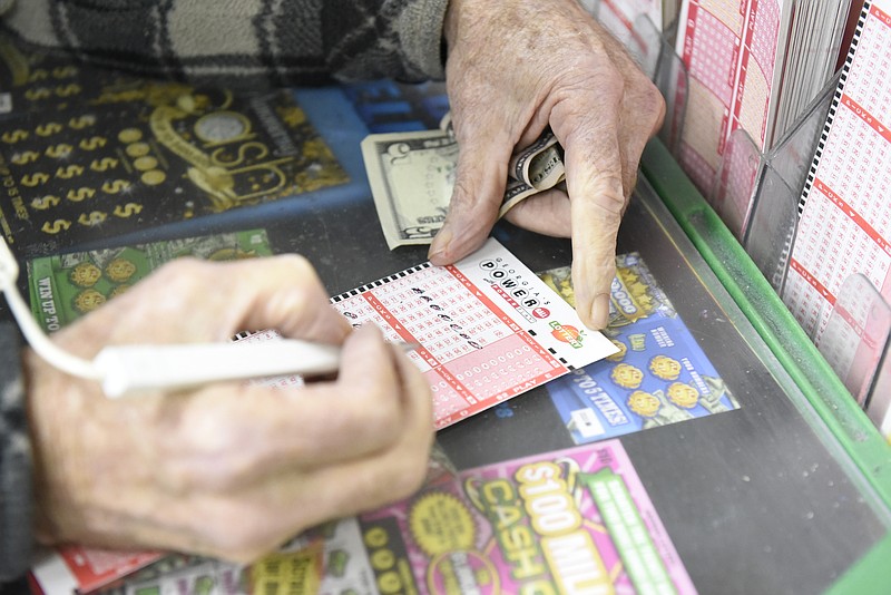 Mervin Hanawalt, of DeKalb Co., Ala., chooses his numbers on a Powerball entry form at the Smart Mart on Highway 301 in Dade County, Ga., just north of the state line on Sunday, Jan. 10, 2016, atop Sand Mountain near Trenton.