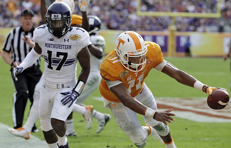 Tennessee quarterback Joshua Dobbs (11) stretches the ball across the goal line after getting past Northwestern cornerback Marcus McShepard (17) on an 18-yard touchdown run during the fourth quarter of the Outback Bowl NCAA college football game Friday, Jan. 1, 2016, in Tampa, Fla. Tennessee won the game 45-6. (AP Photo/Chris O'Meara)