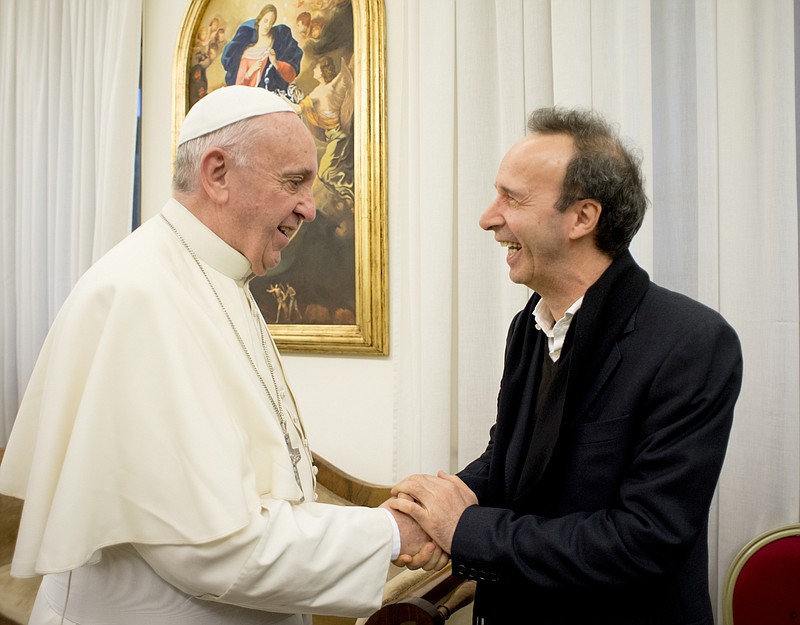
              In this Monday, Jan. 11, 2016 photo, Pope Francis shakes hands with Oscar-winning actor Roberto Benigni after receiving the Italian edition of his first book as pope ' The Name of God is Mercy ', at the Vatican. The Vatican officially launched the book Tuesday with a high-level panel discussion featuring Francis' secretary of state, Cardinal Pietro Parolin, and 'Life Is Beautiful' actor Roberto Benigni, signaling the importance Francis places on getting the message out. (L'Osservatore Romano/Pool Photo via AP)
            