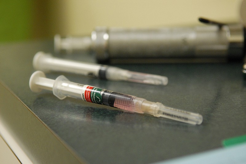 A syringe filled with a dose of rabies vaccination, foreground, sits on the counter at the Red Bank Animal Hospital.