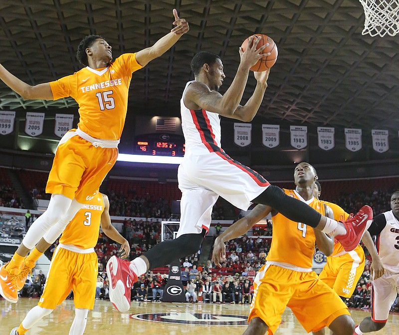 Georgia guard Charles Mann gets a pass off between Tennessee defenders Detrick Mostella, left, and Armani Moore during an NCAA college basketball game Wednesday, Jan. 13, 2016, in Athens, Ga. Georgia won 81-72. (Curtis Compton/Atlanta Journal Constitution via AP)