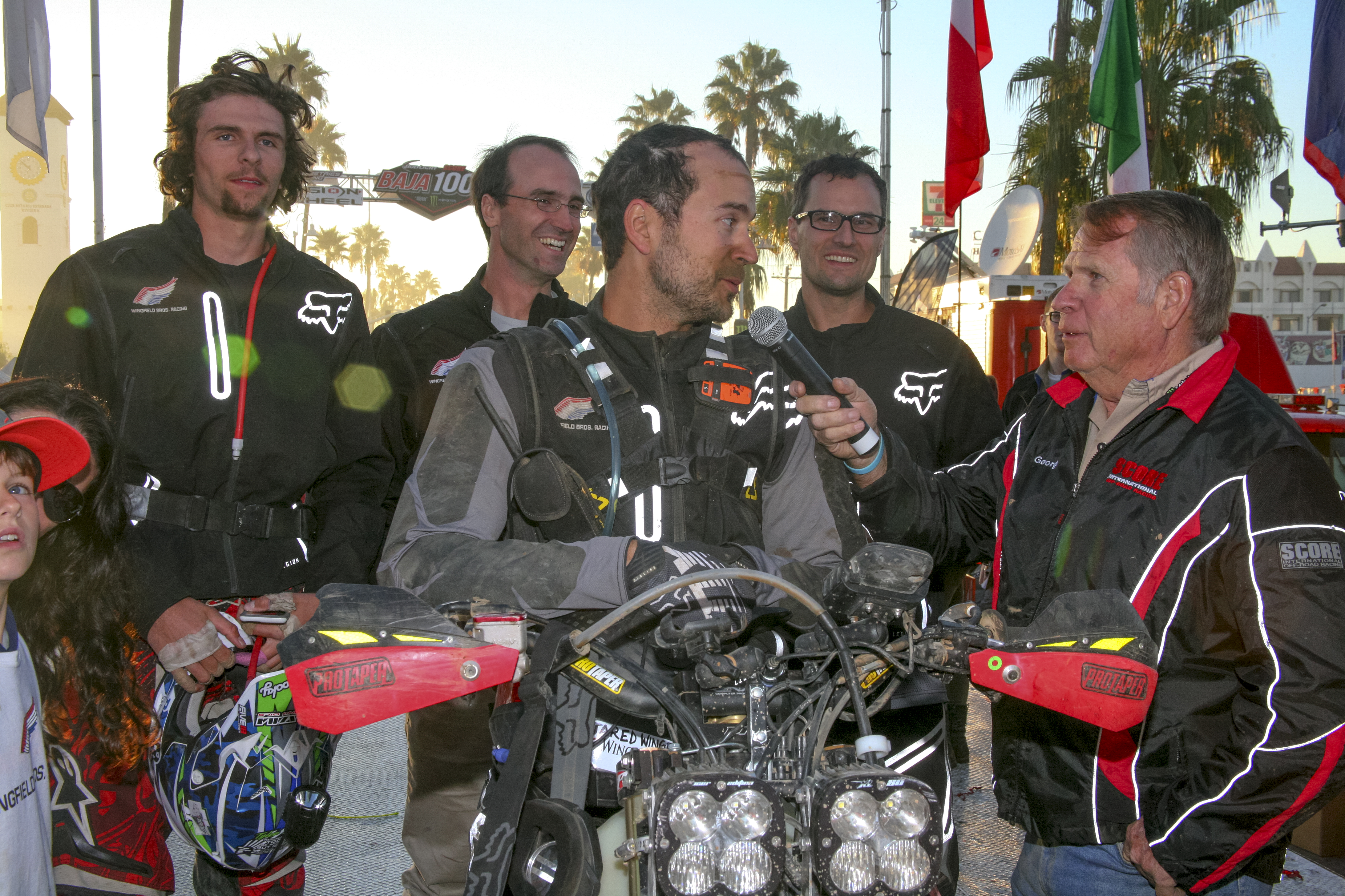 Jared Wingfield, on the bike, is interviewed while surrounded by Wingfield Bros. Racing Team member Braxten Gallian, left, Joseph Wingfield and Jackson Wingfield.