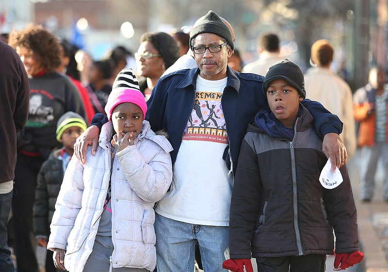 Madison Myers, Rickey Phillips and Joshua Myers march in the M.L. King Day parade on Monday, January 20, 2014, in Chattanooga, Tenn.