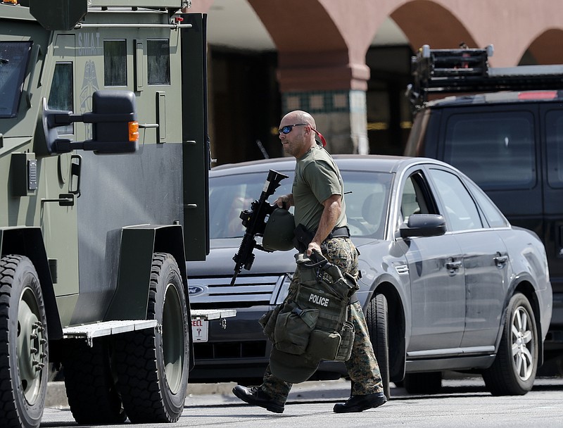 Law enforcement load into an armored vehicle in a staging area on Hixson Pike before leaving to investigate the nearby home of gunman Muhammad Abdulazeez on Thursday, July 16, 2015, in Chattanooga, Tenn. Abdulazeez is the gunman in a shooting at both the Lee Highway Armed Forces Career Center and the Naval Operational Support Center on Amnicola Highway which left five dead, including the shooter, and a Chattanooga police officer wounded.