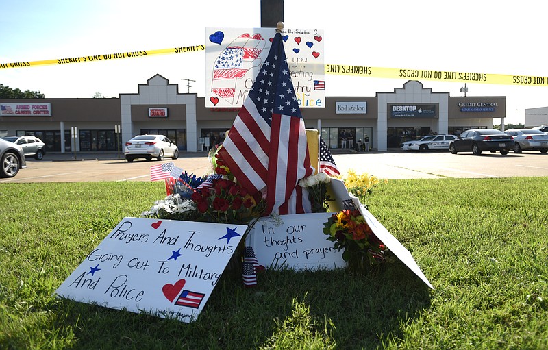 A memorial to shooting victims is in the parking lot near the Armed Forces Career Center, where authorities believe that Muhammad Youssef Abdulazeez fired several rounds into the building before killing four Marines and wounding others in a second attack at another location Thursday, July 16, 2015.