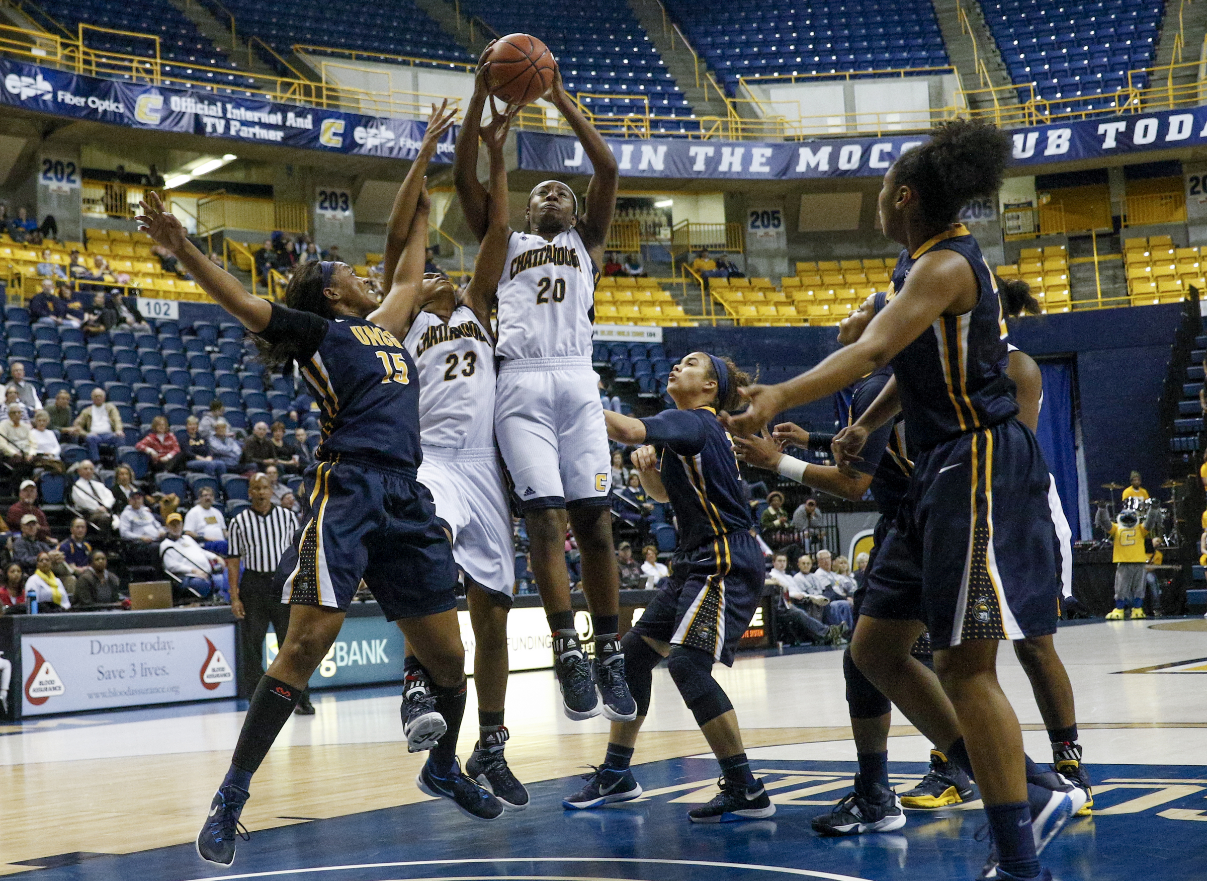 UTC guard Keiana Gilbert (20) rebounds the ball with teammate Moses Johnson (23) against UNCG forward Jade Scaife (15) during the Mocs' home basketball game against UNC-Greensboro at McKenzie Arena on Saturday, Jan. 16, 2016, in Chattanooga, Tenn.