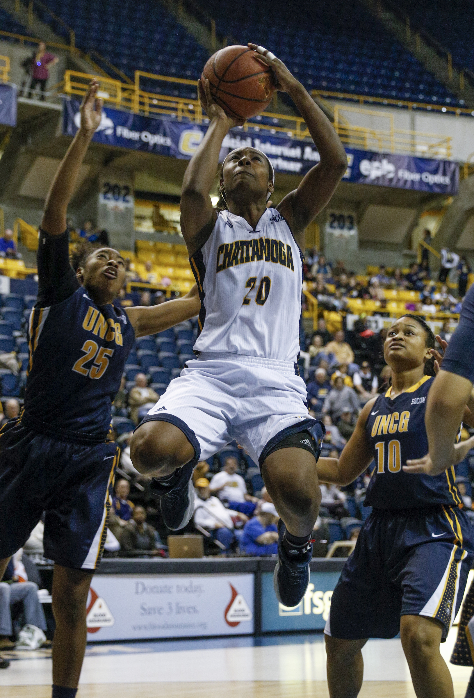 UTC guard Keiana Gilbert (20) shoots between UNCG Guard Shanese Harris (25) and center Gena Penick (10) during the Mocs' home basketball game against UNC-Greensboro at McKenzie Arena on Saturday, Jan. 16, 2016, in Chattanooga, Tenn.
