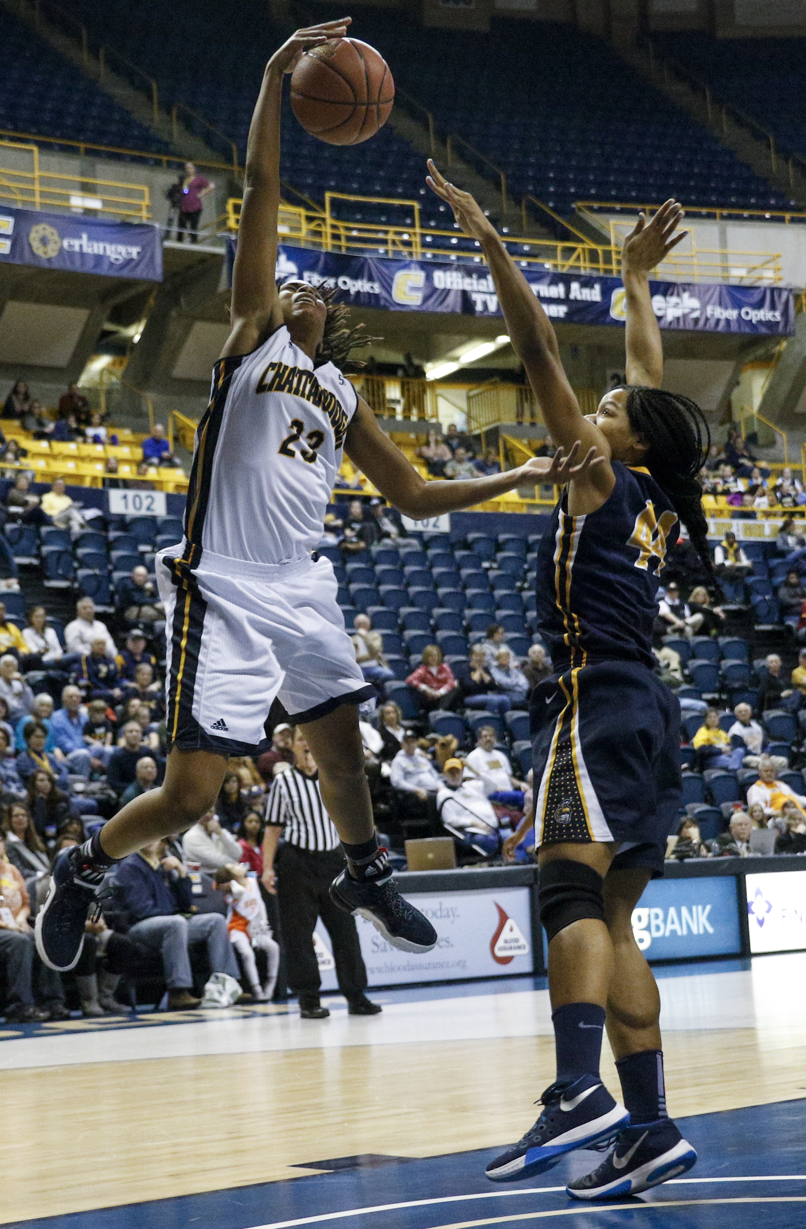 UTC guard Moses Johnson (23) tries to shoot over UNCG center Mariah Wilson during the Mocs' home basketball game against UNC-Greensboro at McKenzie Arena on Saturday, Jan. 16, 2016, in Chattanooga, Tenn.