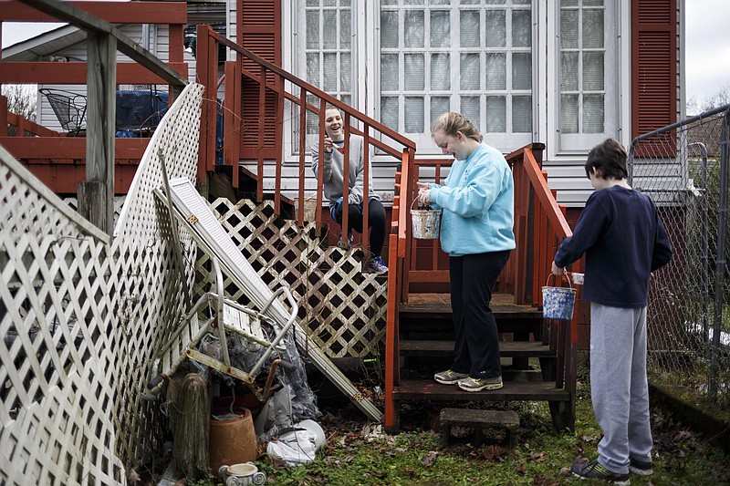 Margaret Elise Allen, Virginia Williams, and Hudson Phillips apply primer to a deck outside the home of Airlean Hutchins, 83, on Saturday, Jan. 16, 2016, in Chattanooga, Tenn. Local volunteers and a Birmingham mission group worked with Widows Harvest Ministries to paint and repair parts of Hutchins's home during a day of service to honor Dr. Martin Luther King, Jr.