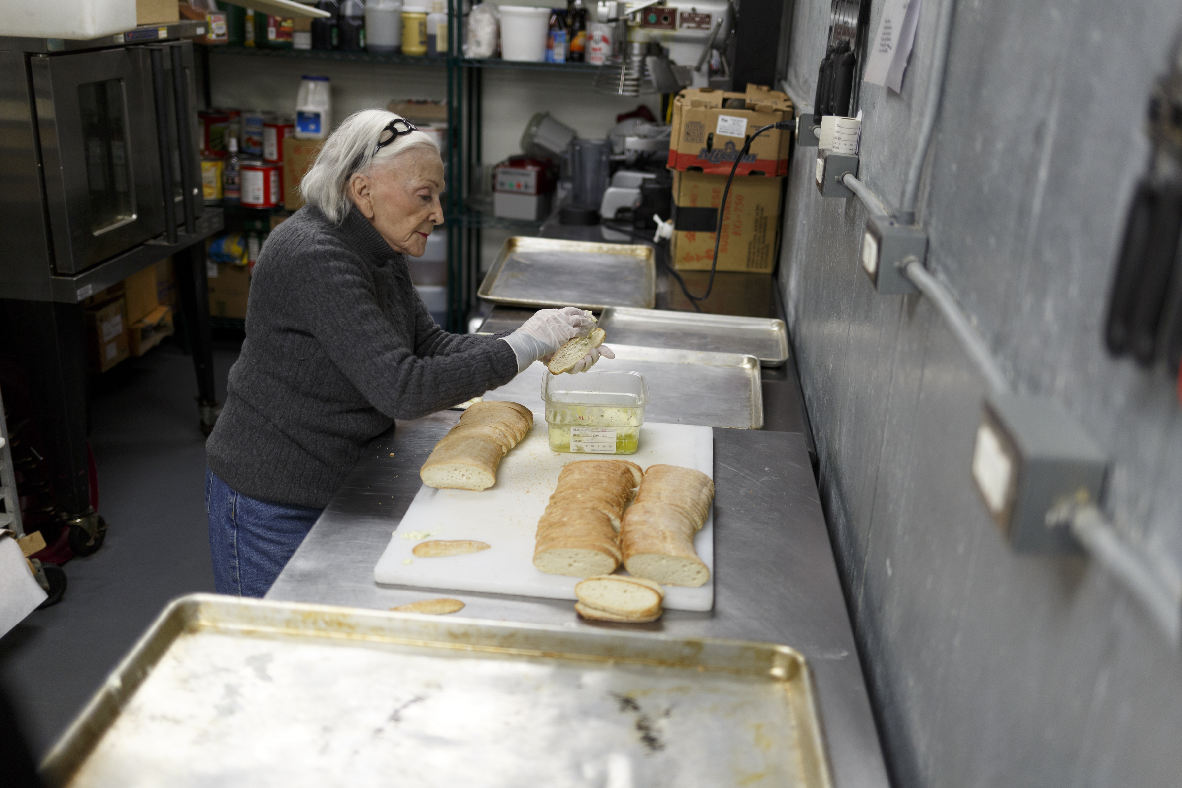 Muriel Rosen butters bread in the kitchen of Five Bar.
