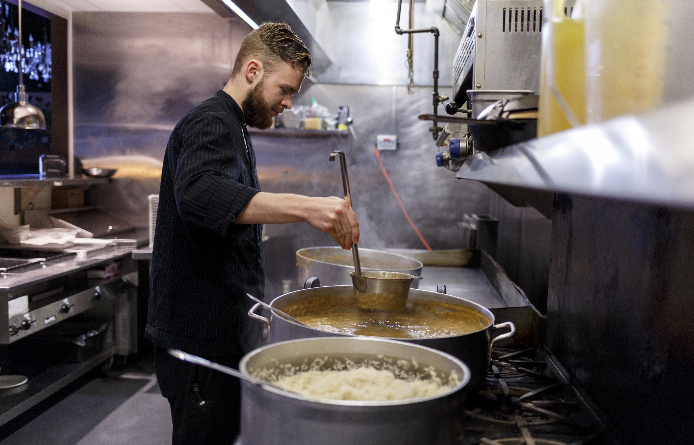 Head chef Jared Little spoons gumbo into portable containers in the kitchen of Five Bar. The gumbo will be loaded into the restaurant's food truck.