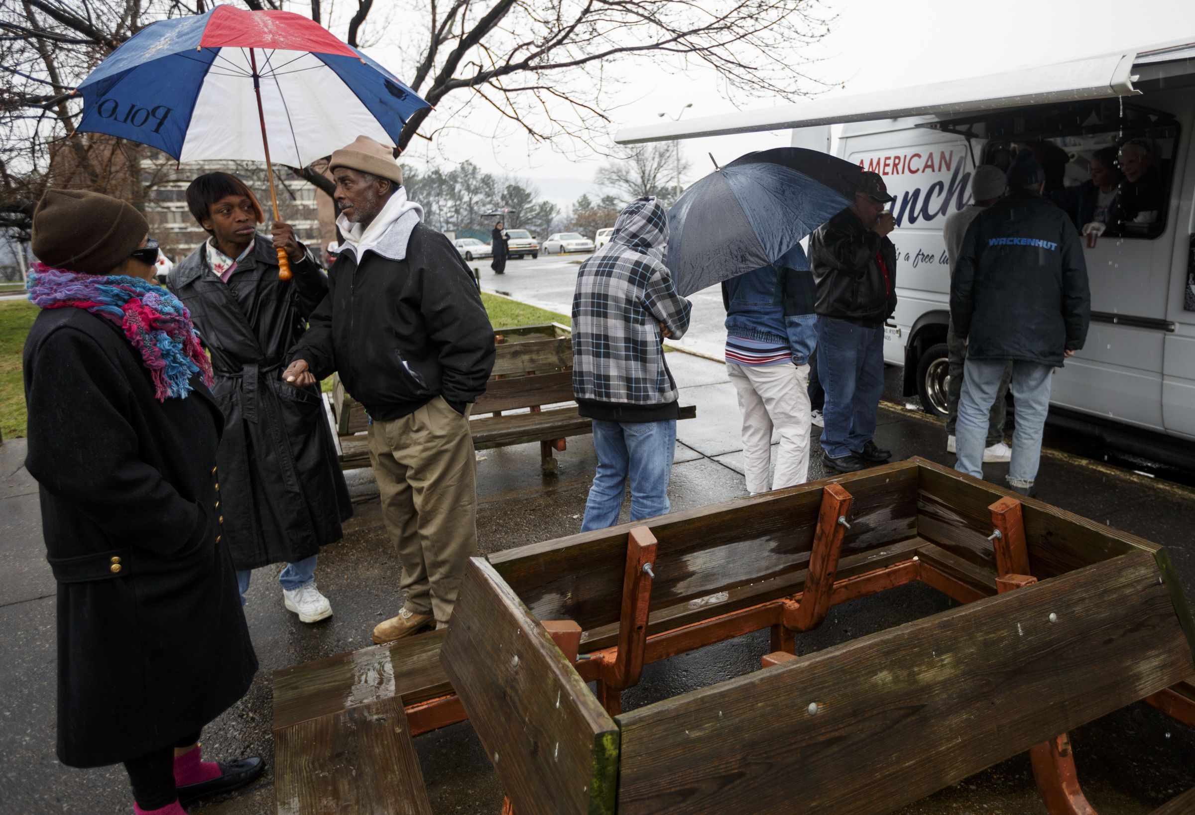 People wait in line outside of the food truck near the Boynton Terrace Apartments on Friday, Jan. 15; the truck, owned by 5 Bar restaurants, serves free lunches on Monday, Wednesday and Friday.