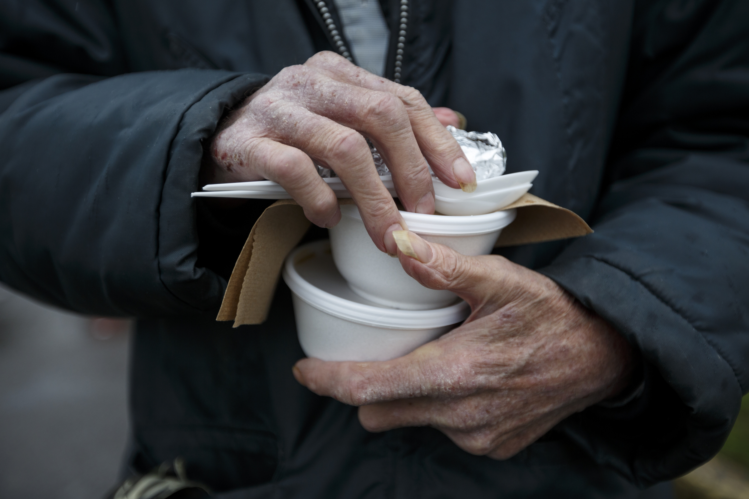 Jerry Hamill carries cups of gumbo back to his Boynton Terrace apartment from the 5 Bar food truck.