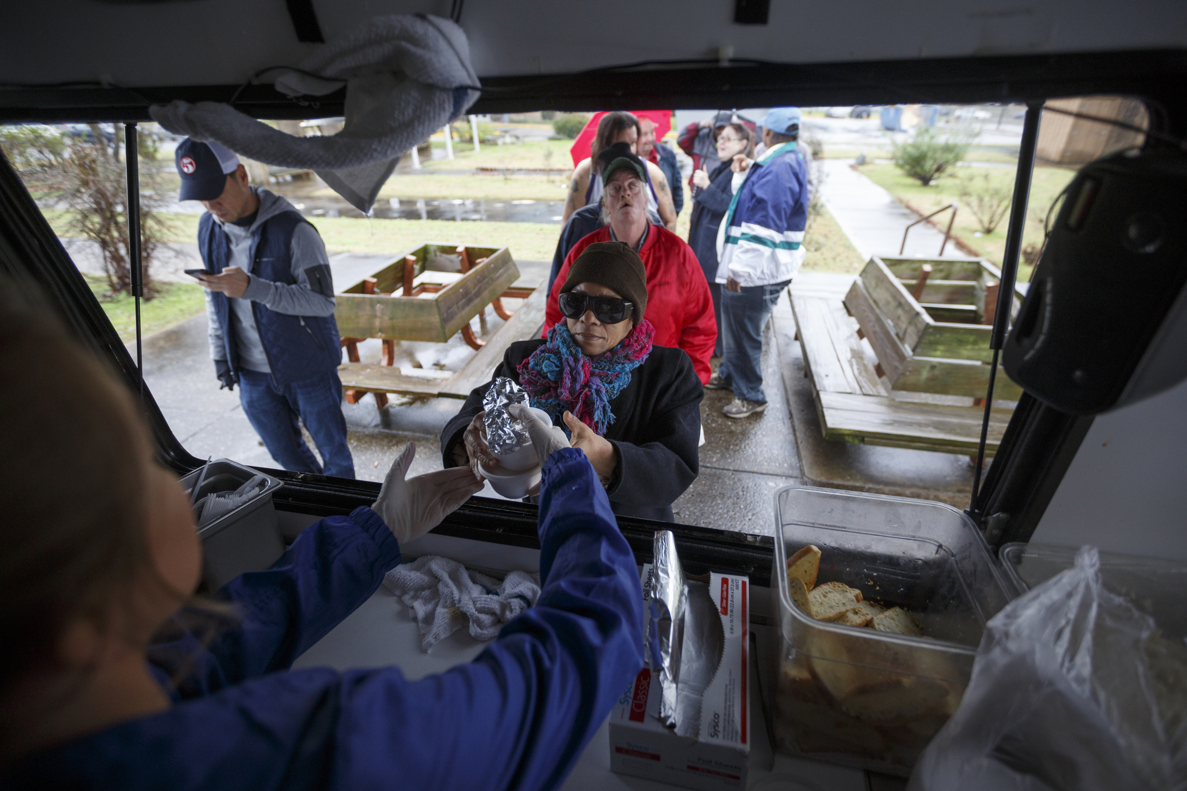 Katie Denham, left, hands cups of gumbo to Henrietta Stevens from the 5 Bar food truck near the Boynton Terrace Apartments.
