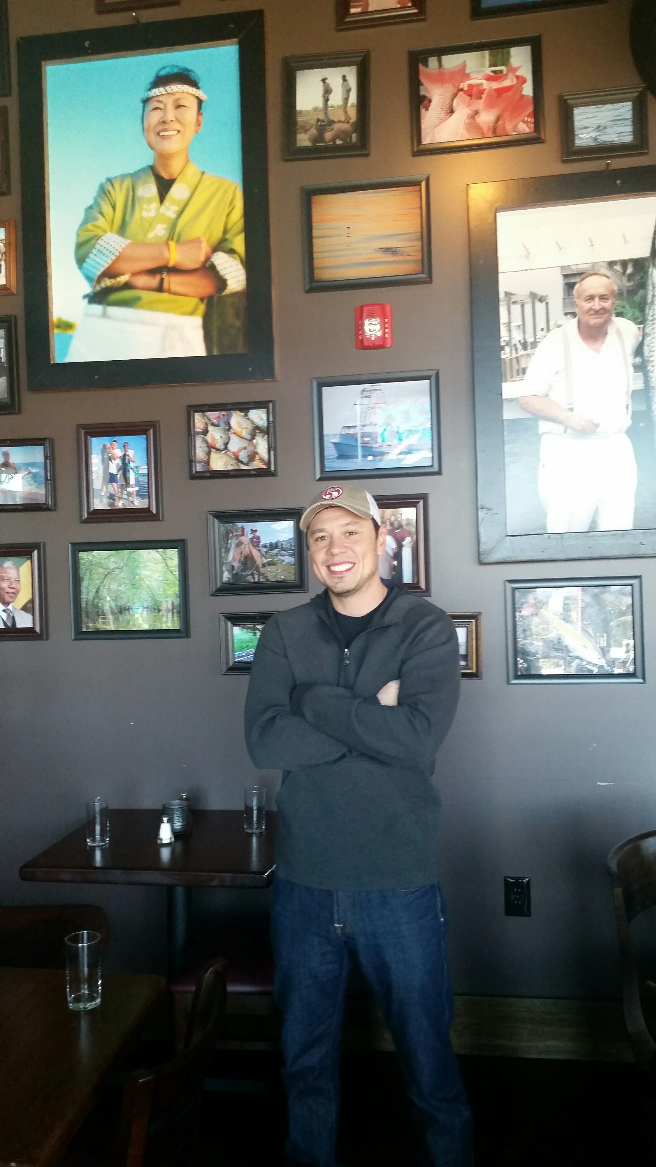 5 Bar restaurant co-owner Cris Eddings covered the restaurant's walls with local art and family photos. The photo of the smiling woman above him is his mother, a popular Florida sushi chef. To his right is a photo of a man holding a fish he just caught; the man famous civil rights attorney Charles Morgan, Jr. who defended champion boxer Muhammad Ali in court in the 1960s. The late Morgan is the father of 5 Bar co-owner Charles Morgan III.