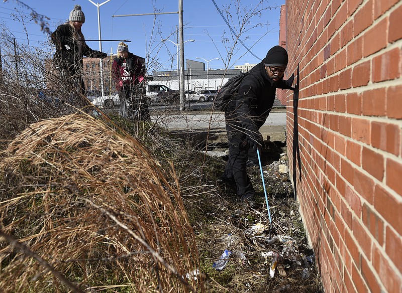 Anna Martino, Balee Price and Michael Harris, from left, pick up trash in a littered lot between 11th and 10th Streets as they and other volunteers participate in a day of service on Monday, Jan. 18, 2016, in Chattanooga, Tenn.