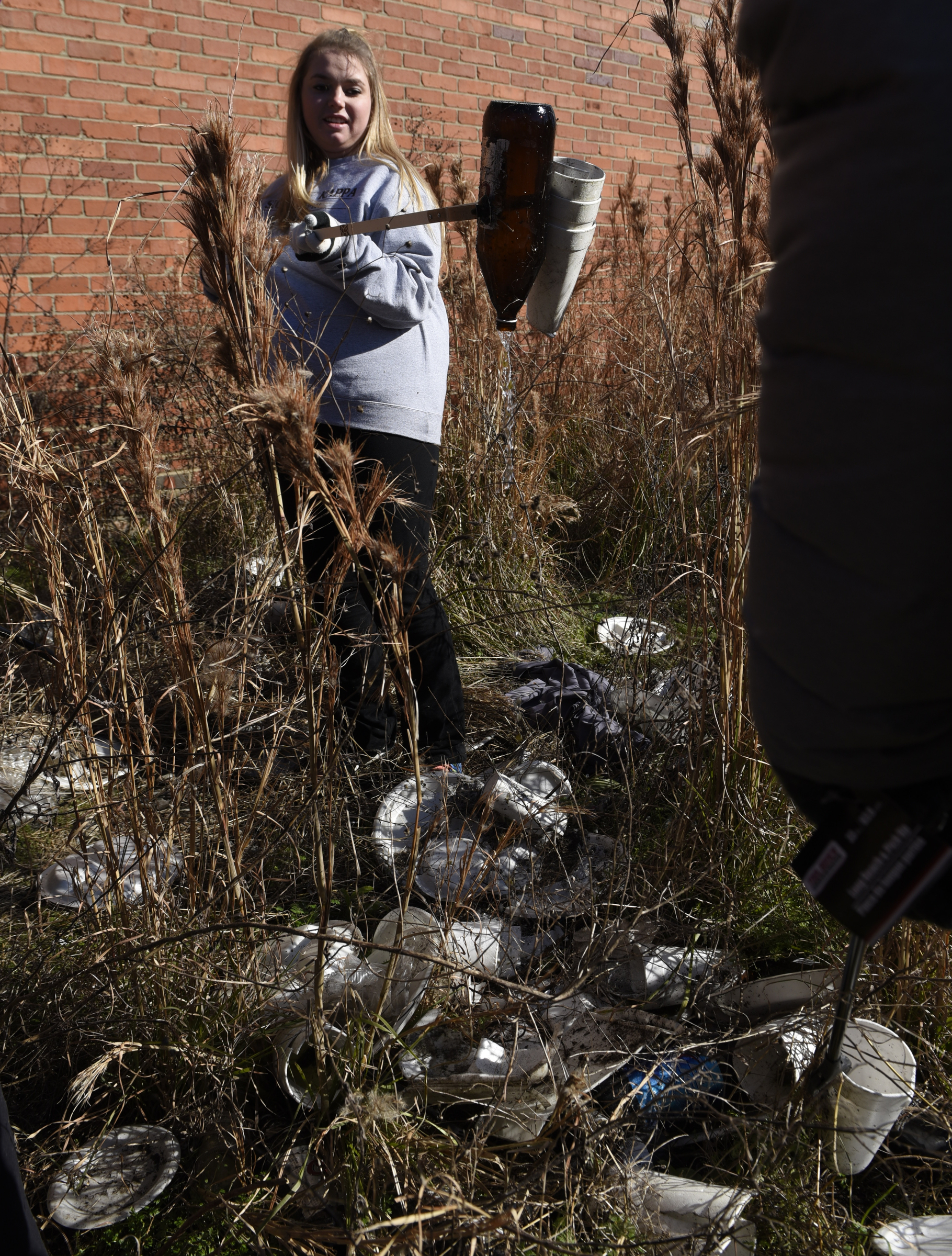 Megan Morrison picks up trash in a littered lot between 11th and 10th Streets as she and other volunteers participate in a day of service on Monday, Jan. 18, 2016, in Chattanooga, Tenn.