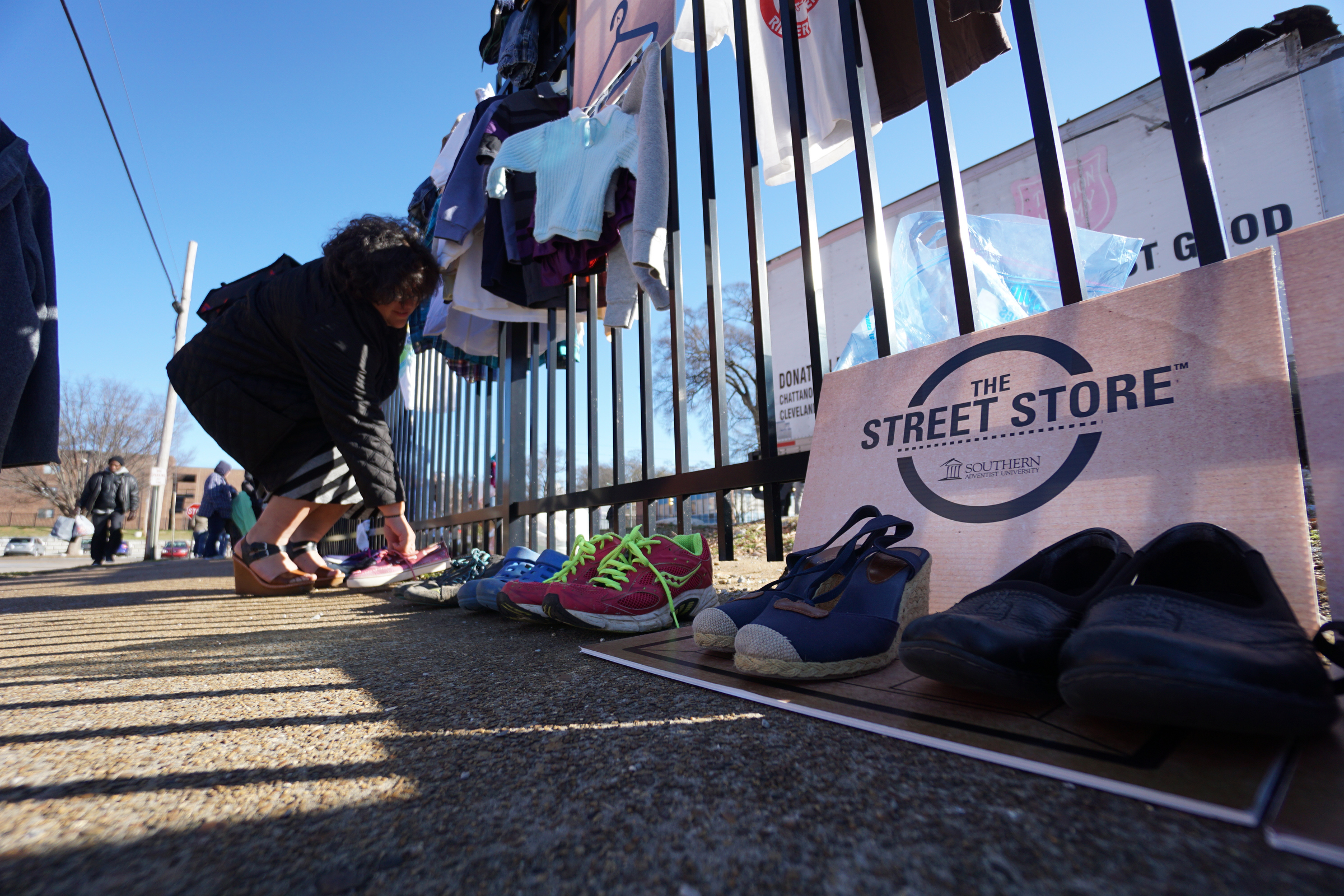 Staff Photo by Dan Henry / The Chattanooga Times Free Press- 1/18/16. Irma Mendoza picks out a new pair of shoes as Southern Adventist University hosts the second annual ғtreet StoreӠin downtown Chattanooga in partnership with the Salvation Army on January 18, 2016. Street Stores are sidewalk pop-up shops that offers free clothes to the homeless, providing them with a dignified shopping experience as they try on and select their own garments. More than 4,000 individuals experience homelessness each year in Chattanooga alone.