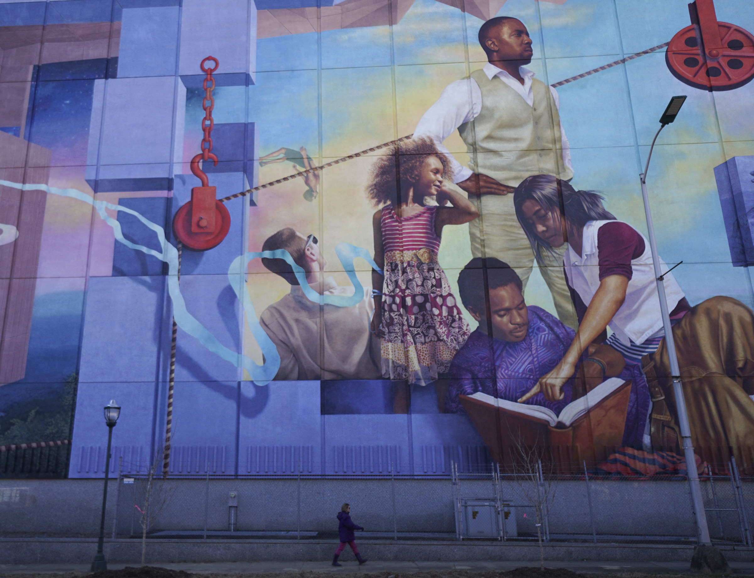 Staff Photo by Dan Henry / The Chattanooga Times Free Press- 1/18/16. A pedestrian walks past the $200,000 M.L. King Blvd. mural after a dedication for the project on January 18, 2016.
