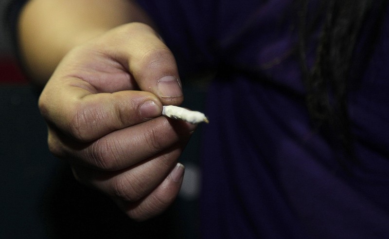 
              FILE - In this Dec. 6, 2012, file photo, a person holds a freshly-rolled marijuana joint just after midnight at the Space Needle in Seattle. A new analysis released Monday, Jan. 18, 2016, is challenging the idea that smoking marijuana during adolescence can lead to declines in intelligence. Instead, the new study says, pot smoking may be merely a symptom of some other problem that is really responsible for a brainpower effect seen in some previous research. (AP Photo/Ted S. Warren, File)
            