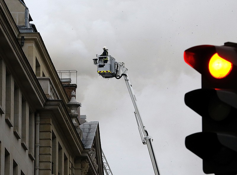 
              A French firefighter stands atop a fire ladder as a fire engulfed the top floor of Paris’ Ritz Carlton hotel, Tuesday, Jan. 19, 2016 in Paris. The hotel has been closed for renovations for three years and was expected to re-open in March, restored to the grandeur that drew the likes of Frederic Chopin, Coco Chanel and Ernest Hemingway. (AP Photo/Jacques Brinon)
            