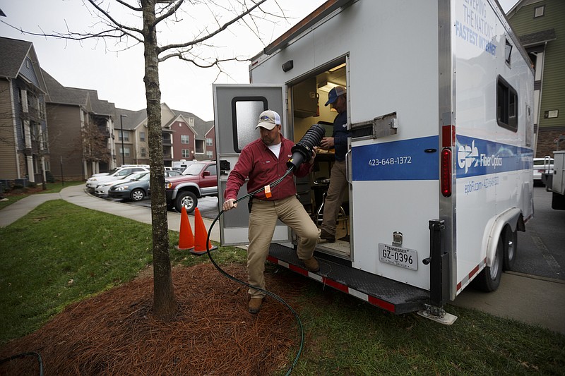 Staff file photo / Service technicians Stacy Mann, left, and Nathen Lloyd step out of an EPB trailer with a newly installed fiber optics cable during an installation at CityGreen Apartments in Chattanooga's North Shore area in 2016.	