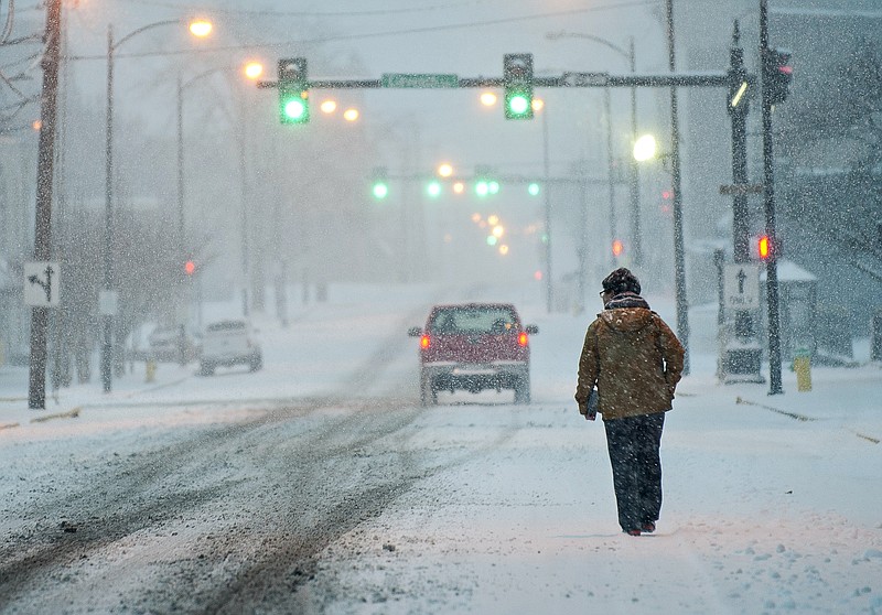 Jason Lee, a Western Kentucky University student from Korea, walks in the falling snow Wednesday, Jan. 20, 2016, in Bowling Green, Ky. 