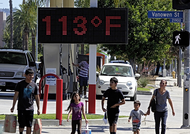 
              FILE - In this Aug. 15, 2015 file photo, pedestrians walk past a digital thermometer reading 113 degrees Fahrenheit in the Canoga Park section of Los Angeles. Earth last year wasn’t just the hottest year on record, but it left a century of temperature high marks in its hot dust. The National Oceanic Atmospheric Administration (NOAA) and NASA announced Wednesday, Jan. 20, 2016, that 2015 was by far the hottest year in 136 years of record keeping. (AP Photo/Richard Vogel, File)
            