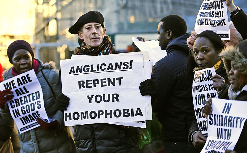 Human rights campaigner Peter Tatchell, center, demonstrates with others against the decision by the Anglican Communion to not allow the Episcopal Church to vote on decisions of policy and doctrine as a response to the Episcopal Church's acceptance of homosexuality and same-sex marriage.