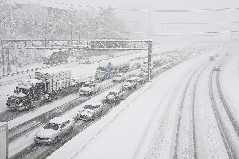 Snow slows down traffic on Interstate 40, Friday morning, Jan. 22, 2016, in Nashville, Tenn. A blizzard menacing the Eastern United States started dumping snow in Virginia, Tennessee and other parts of the South on Friday as millions of people in the storm's path prepared for icy roads, possible power outages and other treacherous conditions. (Andrew Nelles/The Tennessean via AP)