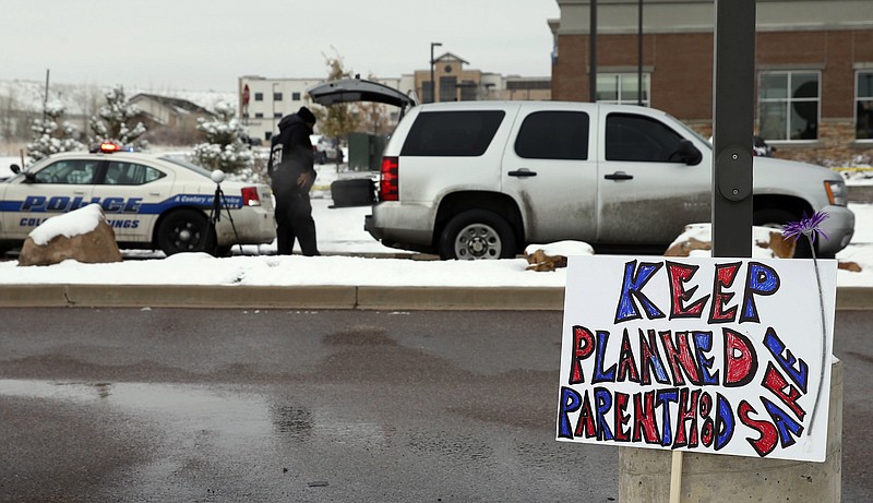 
              FILE - In this Nov. 29, 2015 file photo, a sign in support of Planned Parenthood stands just south of the clinic as police investigators gather evidence near the scene of a shooting at the clinic in Colorado Springs, Colo. Abortion and reproductive rights are never far from the nerve in this battleground state, where party affiliation is roughly even between Democrats and Republicans and statewide contests often come down to the votes of suburban women who belong to neither party.(AP Photo/David Zalubowski, File)
            