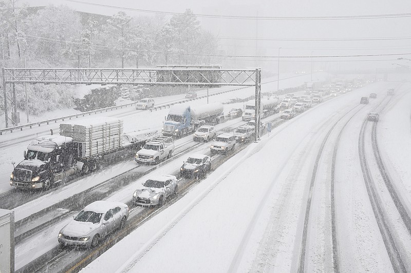 
              Snow slows down traffic on Interstate 40, Friday morning, Jan. 22, 2016, in Nashville, Tenn. A blizzard menacing the Eastern United States started dumping snow in Virginia, Tennessee and other parts of the South on Friday as millions of people in the storm's path prepared for icy roads, possible power outages and other treacherous conditions. (Andrew Nelles/The Tennessean via AP)
            