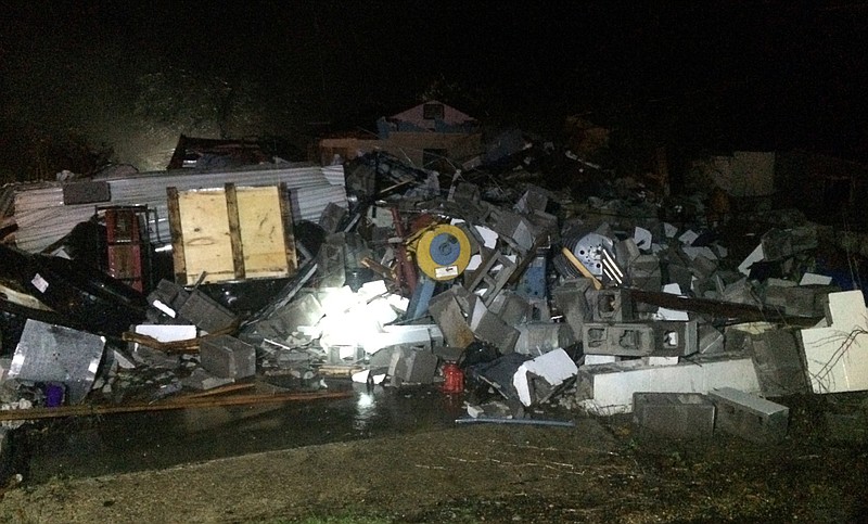 Debris covers a home after a severe storm damaged a number of homes, fell trees and dropped power lines in the Oloh community in Lamar County, Miss., Thursday night, Jan. 21, 2016. The Oak Grove search and rescue team was mobilized. The storm was part of a day of rain storms throughout the state. Snow and ice accumulations are expected in some of the northern counties early Friday morning. (Ryan Moore/WDAM-TV, via AP)