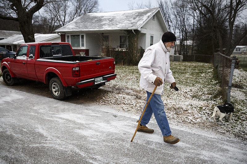 Gus Spahr walks his dog Marlowe on Ridgeway Drive after winter storm Jonas swept across the Eastern United States on Saturday, January 23, 2016, in Red Bank, Tenn. While much of the East Coast received heavy snowfall, the Tennessee Valley was less effected.