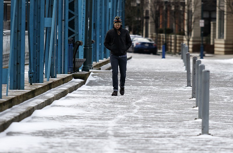 Sam Lensgraf walks on the iced-over Walnut Street Bridge after winter storm Jonas swept across the Eastern United States on Saturday, January 23, 2016, in Chattanooga, Tenn. While much of the East Coast received heavy snowfall, the Tennessee Valley was less effected.
