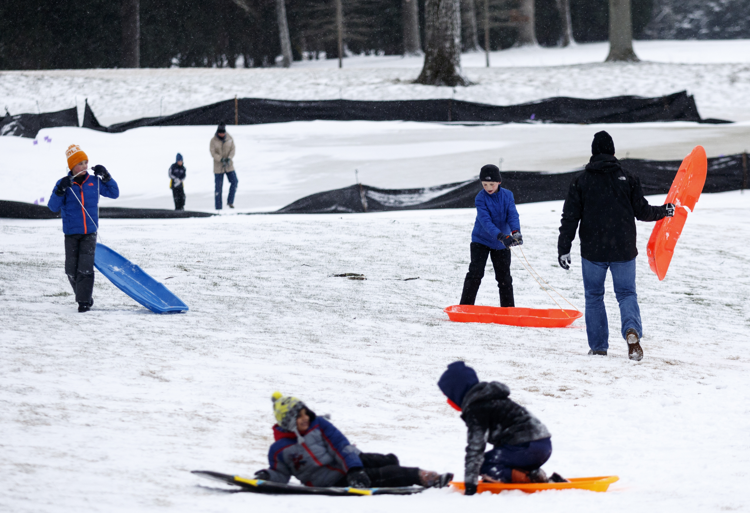 People sled on a fairway of the Signal Mountain Golf and Country Club after winter storm Jonas swept across the Eastern United States on Saturday, January 23, 2016, in Signal Mountain, Tenn. While much of the East Coast received heavy snowfall, the Tennessee Valley was less effected.